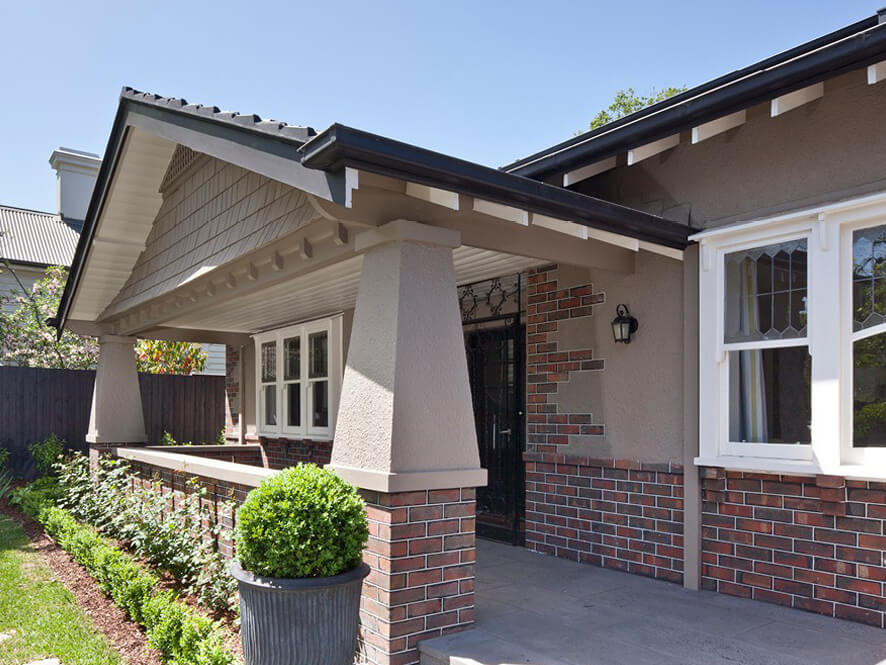 Painted Brick Modern Design with White Window Trims and Tiled Porch with Green Garden